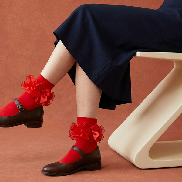 Red ruffle and bow ankle socks styled with brown Mary Jane shoes and a navy skirt.