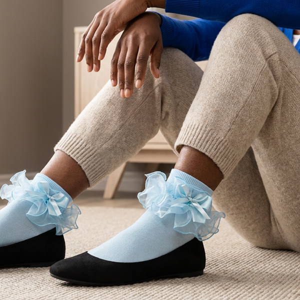 Pale blue ruffle bow ankle socks worn with black ballet flats and cropped cream trousers.
